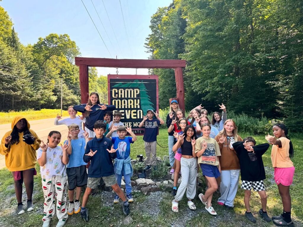 children in front of mark seven board